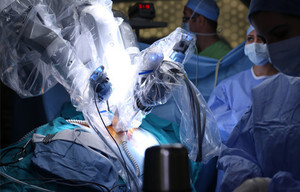 surgeons around an operating robot